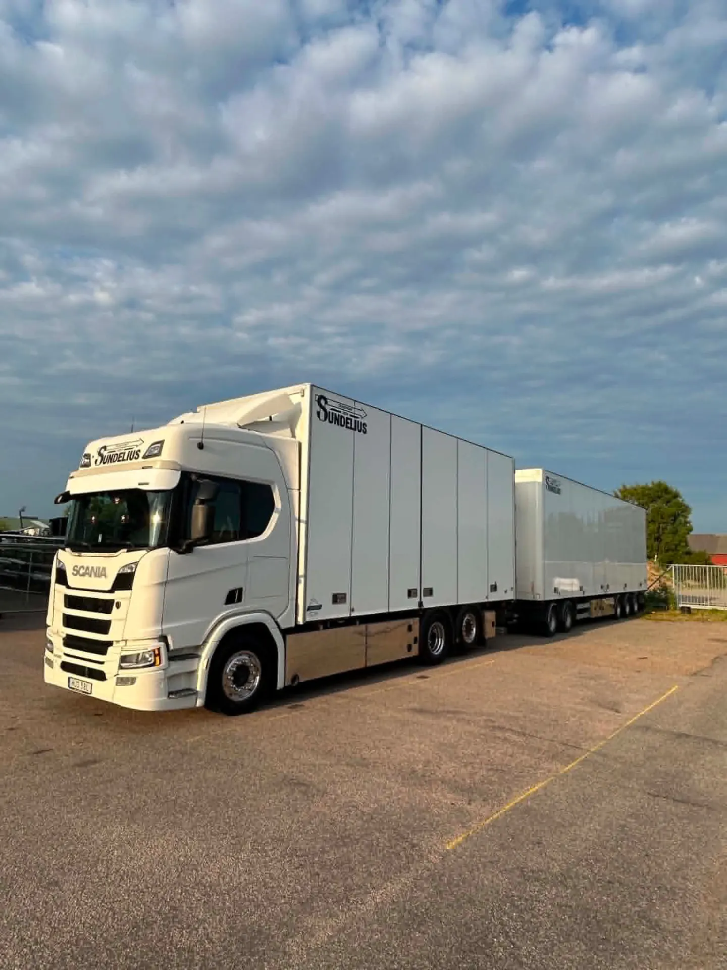 Scania-ekipage med släp från T.Sundelius Transport uppställt på asfaltsplan